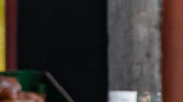 Women with a red sombrero and Mexico flag standing in front of a red lowrider