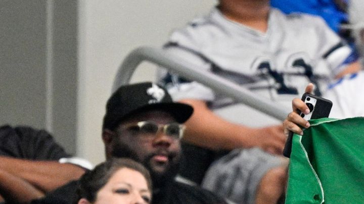 A spectator holds a Mexican flag during the second half of an NFL football game between the Dallas Cowboys and the New Orleans Saints, Sunday, Sept. 15, 2024, in Arlington, Texas. (AP Photo/Jerome Miron)