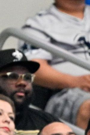 A spectator holds a Mexican flag during the second half of an NFL football game between the Dallas Cowboys and the New Orleans Saints, Sunday, Sept. 15, 2024, in Arlington, Texas. (AP Photo/Jerome Miron)